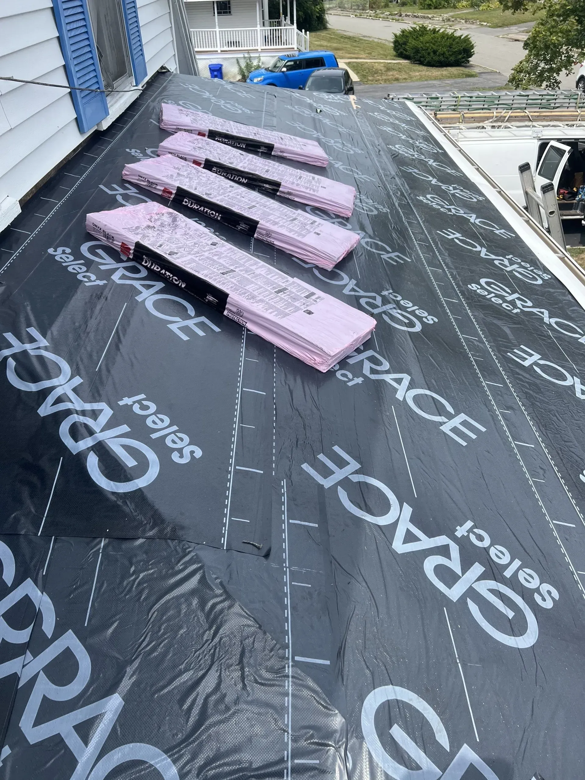 Roof with black underlayment and pink insulation panels.