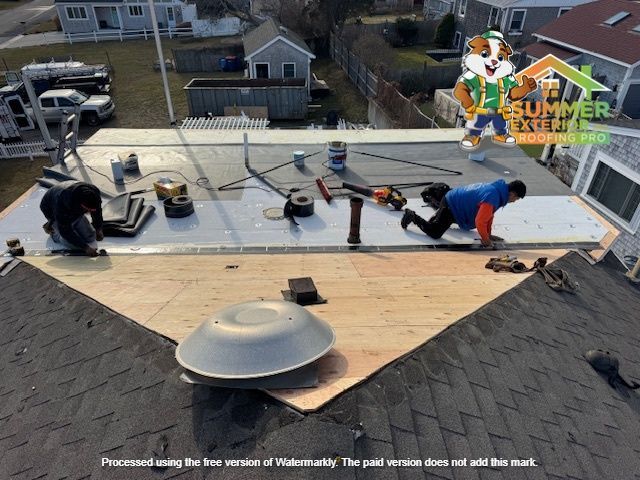 Roofers installing a new flat roof on a residential building.
