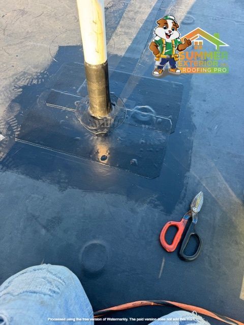 Black roofing material with a pipe, scissors, and a cartoon logo in the corner.