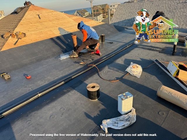 Roofers working on a flat roof. A cartoon mascot is visible.