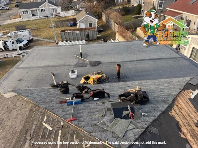 Roofing work in progress, tools scattered on shingles. Cartoon badger logo.