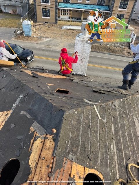 Roofers removing a chimney on a weathered roof; cityscape backdrop.