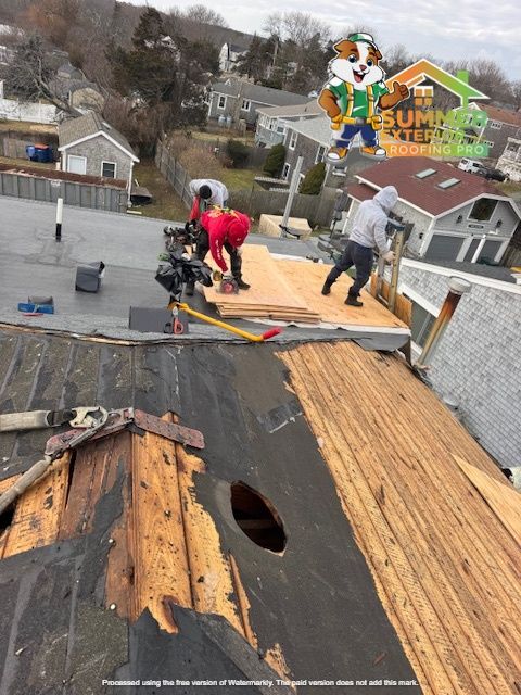 Roofers working on a building, partially removing old roof. Summit Exteriors logo in top right.