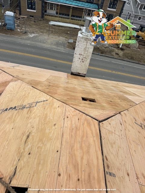 Wooden roof with chimney, cartoon mascot, and street in the background.