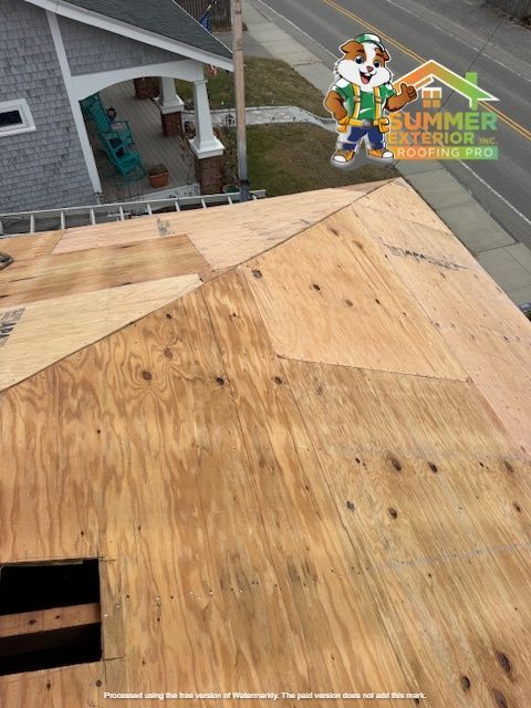 Plywood roof partially installed, with Summer Exterior Roofing logo. Building in background.