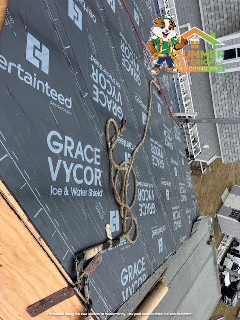 Roofer installing Grace Vycor ice and water shield on a roof; safety harness, rope, black underlayment.