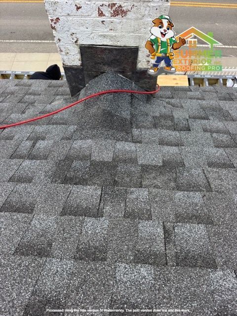 Roof with gray shingles, chimney, and cartoon mascot. Red wire visible.