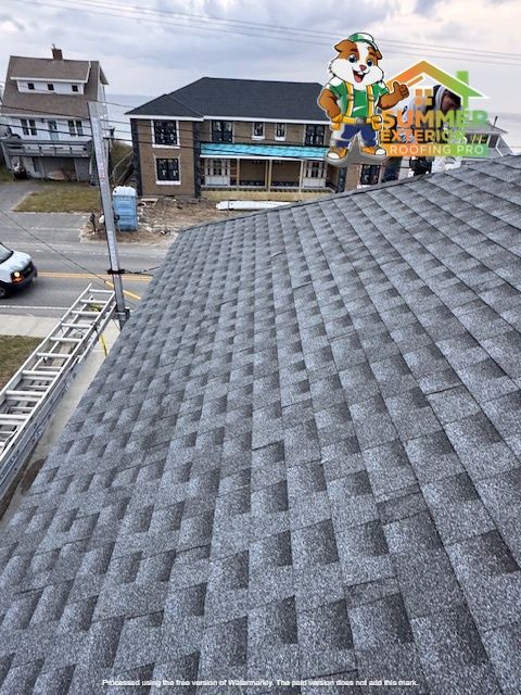 Newly installed gray shingle roof, with a cartoon mascot, overlooking neighborhood houses.