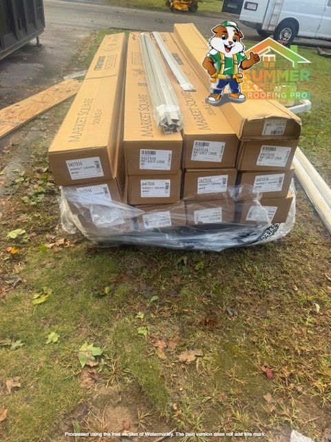 Boxes of window components on grass, with cartoon mascot.