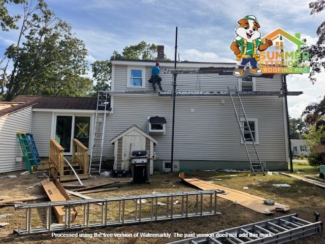 Construction workers on a two-story home, using ladders and scaffolding to work on the roof and siding.
