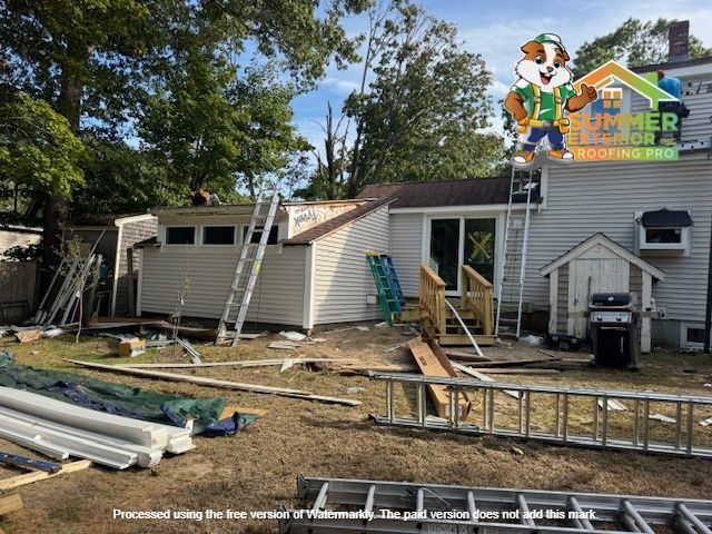 Construction on a home's roof with ladders, materials, and workers; exterior setting.