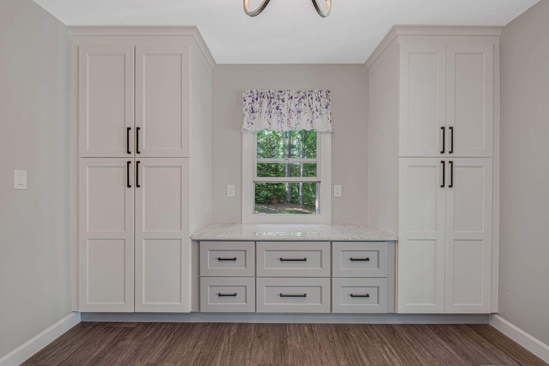 A room with white cabinets and drawers