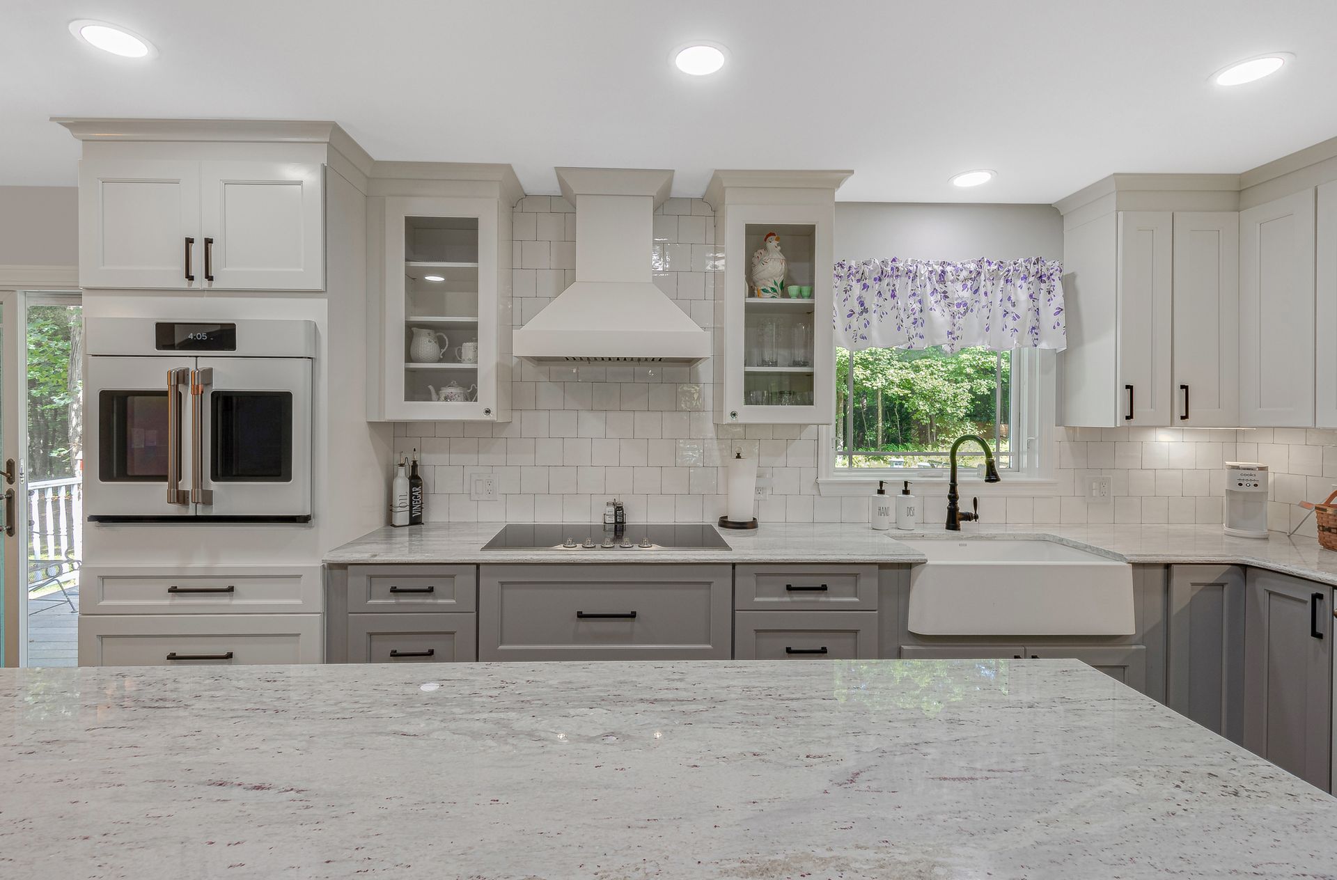 A kitchen with white cabinets and granite counter tops