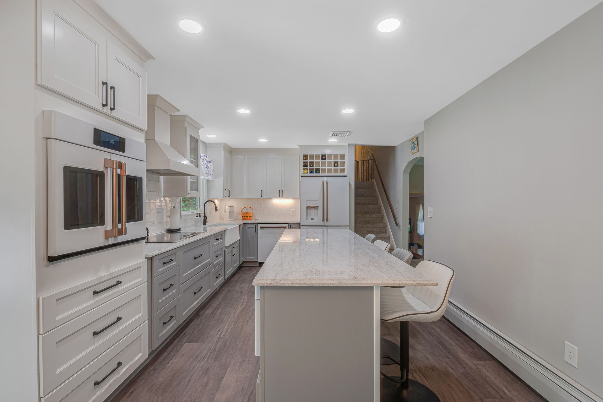 A kitchen with white cabinets and a large island
