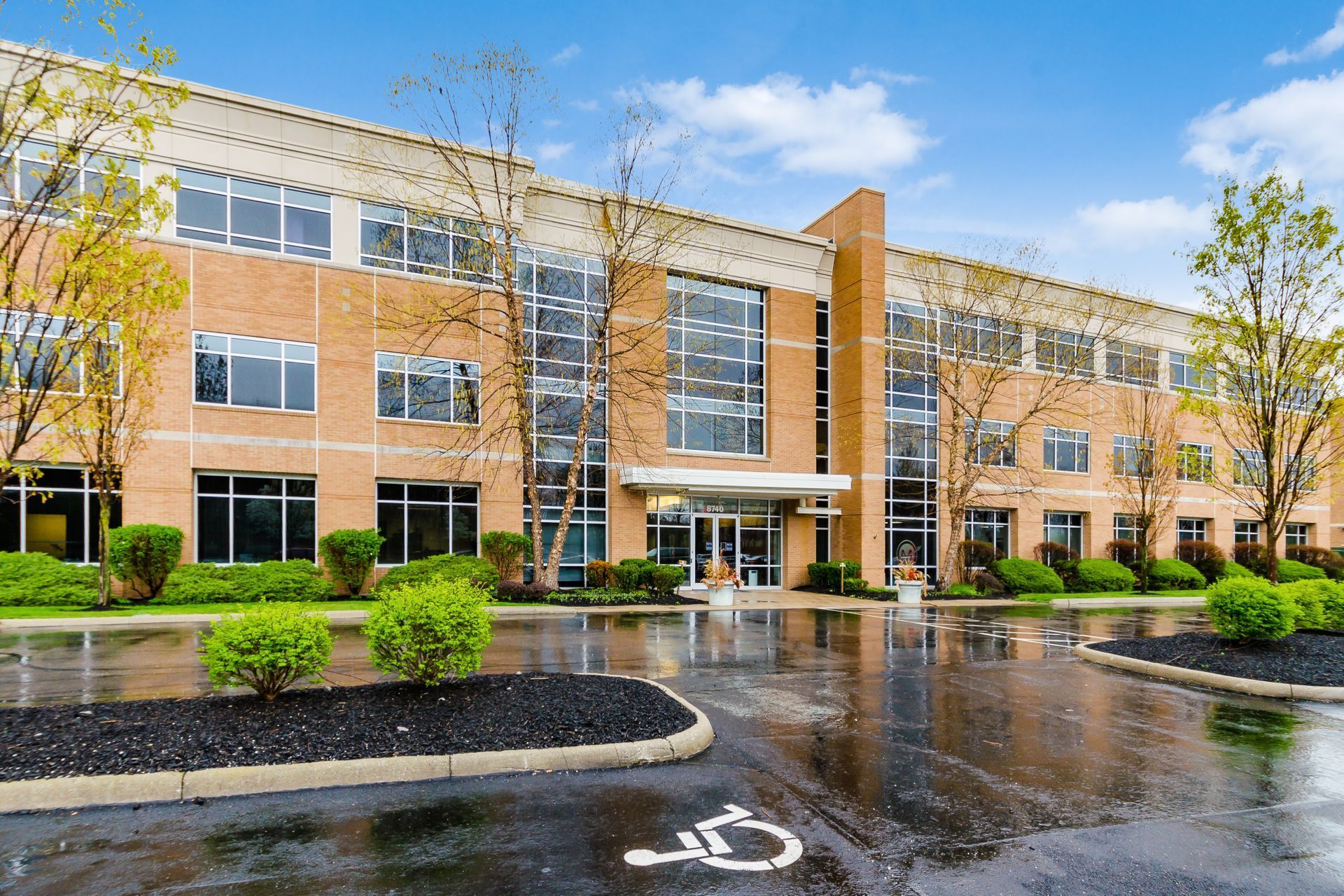 A large brick building with a handicapped parking spot in front of it.