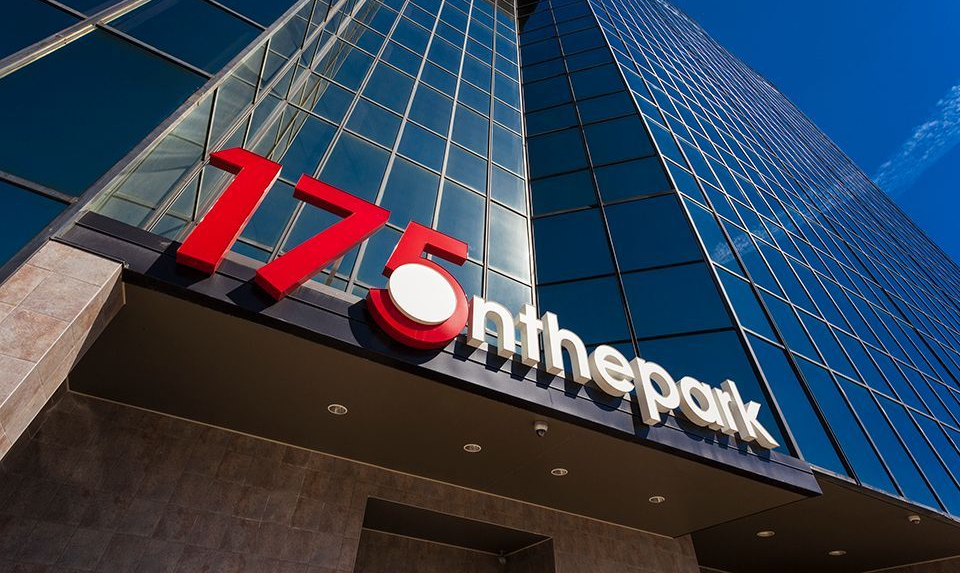 175 on the Park building sign; red numbers and text on a modern glass building facade.
