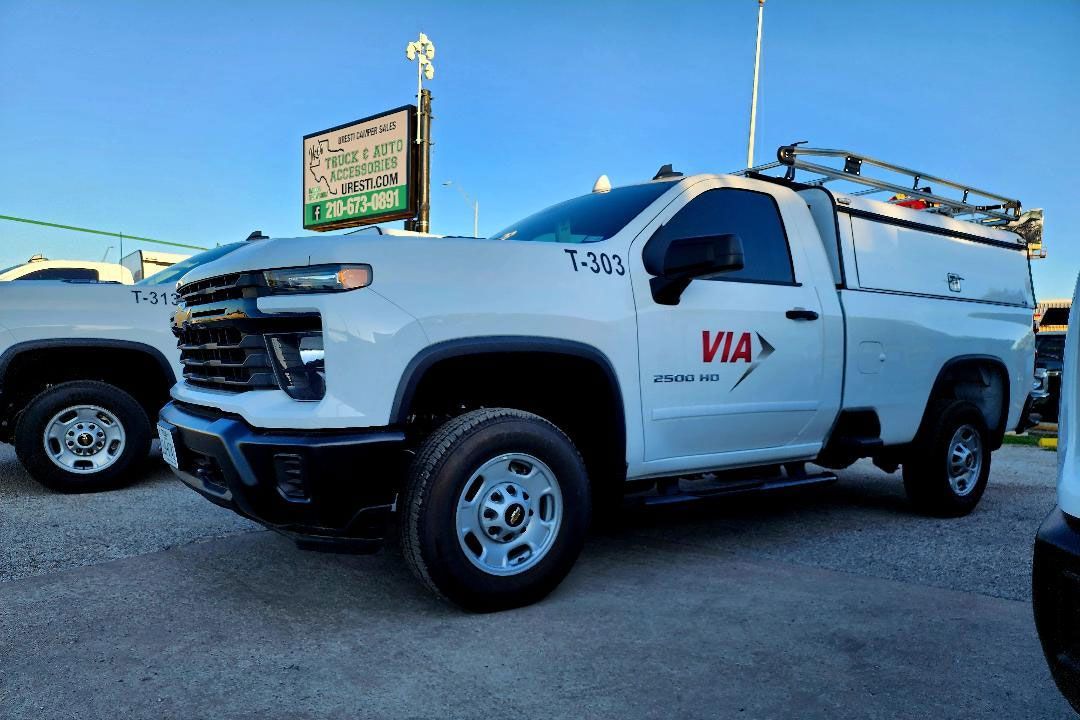White VIA service truck parked outside with a commercial topper
