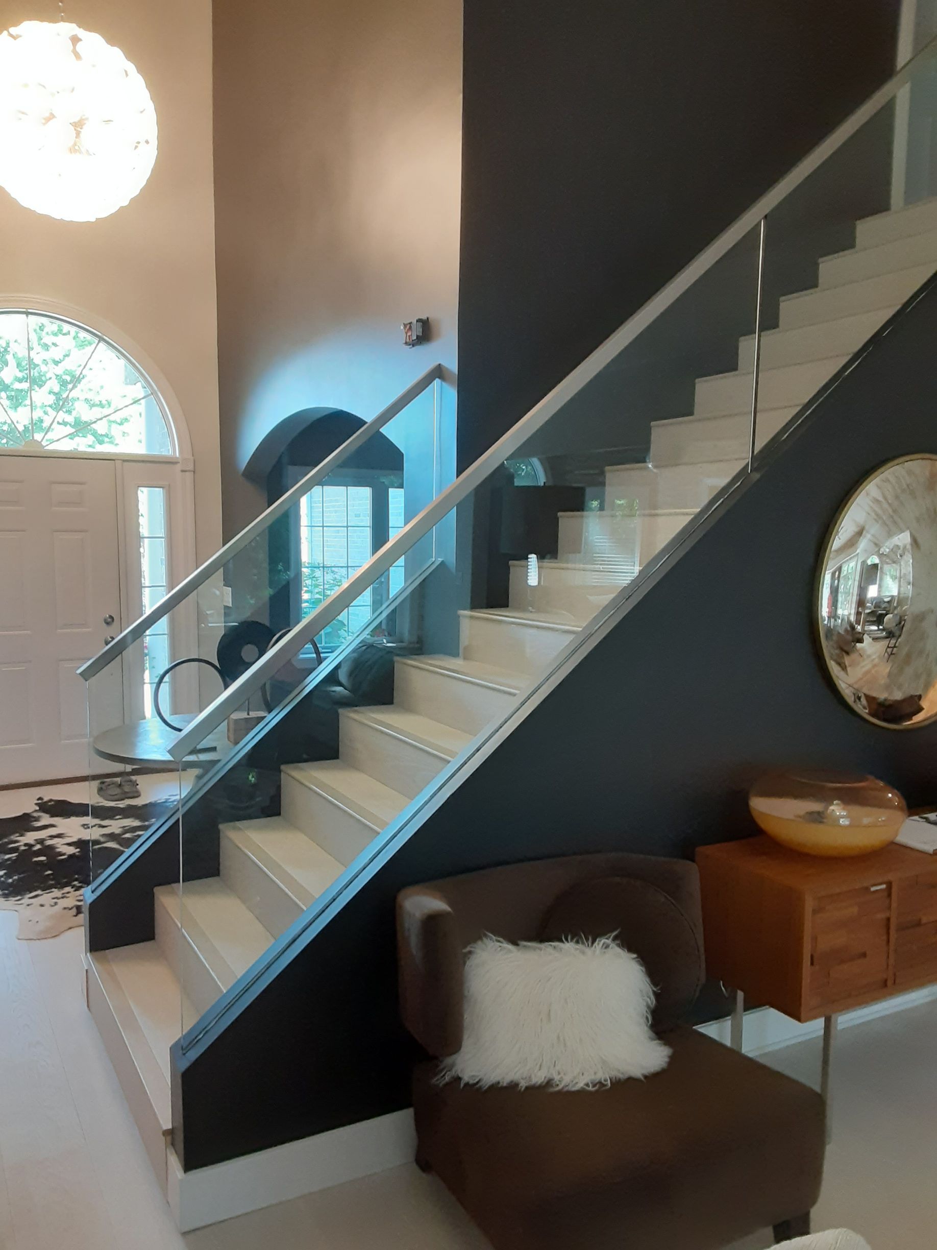 A staircase with a glass railing in a living room