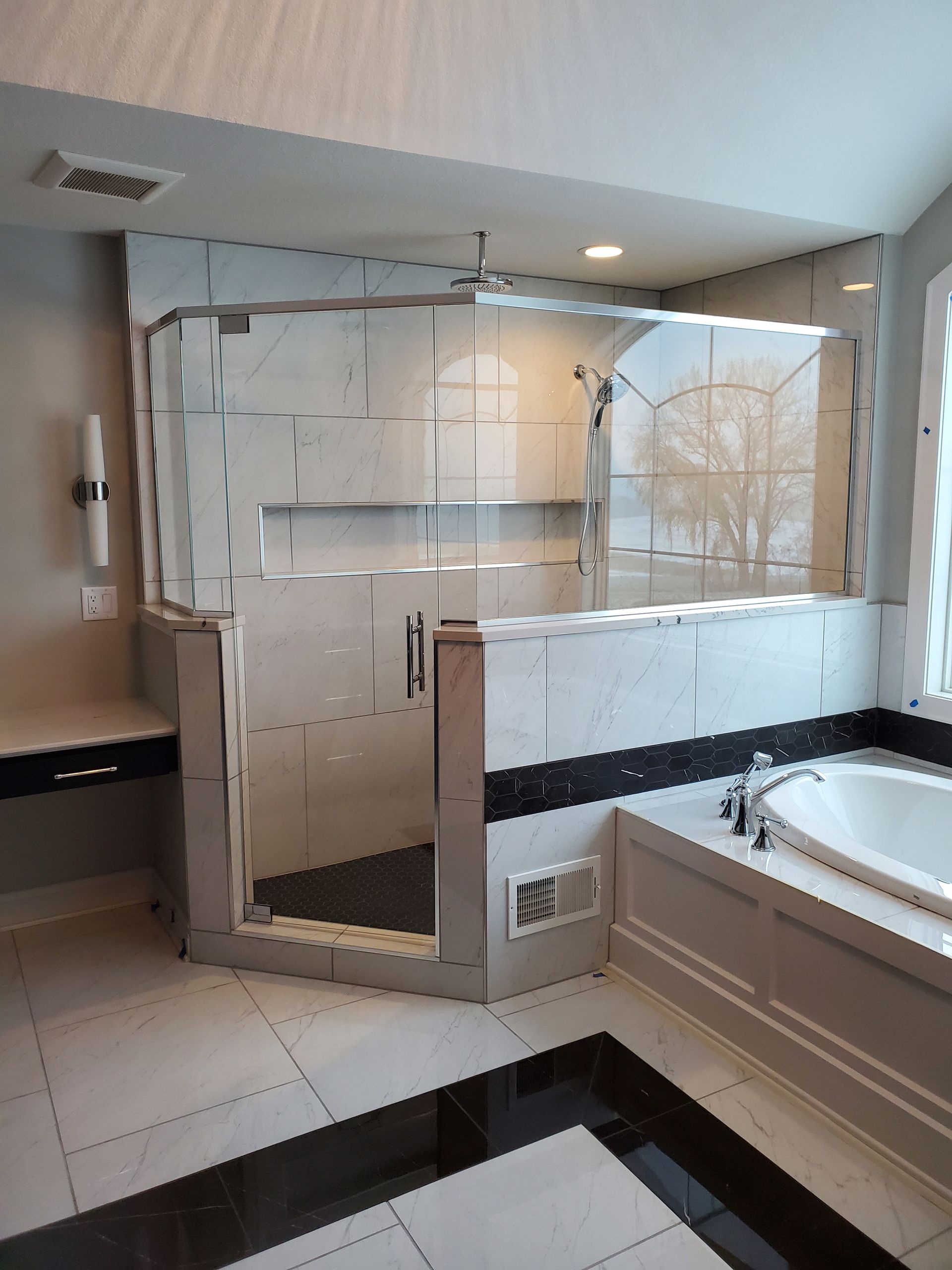 A bathroom with a tub, shower, and mirror