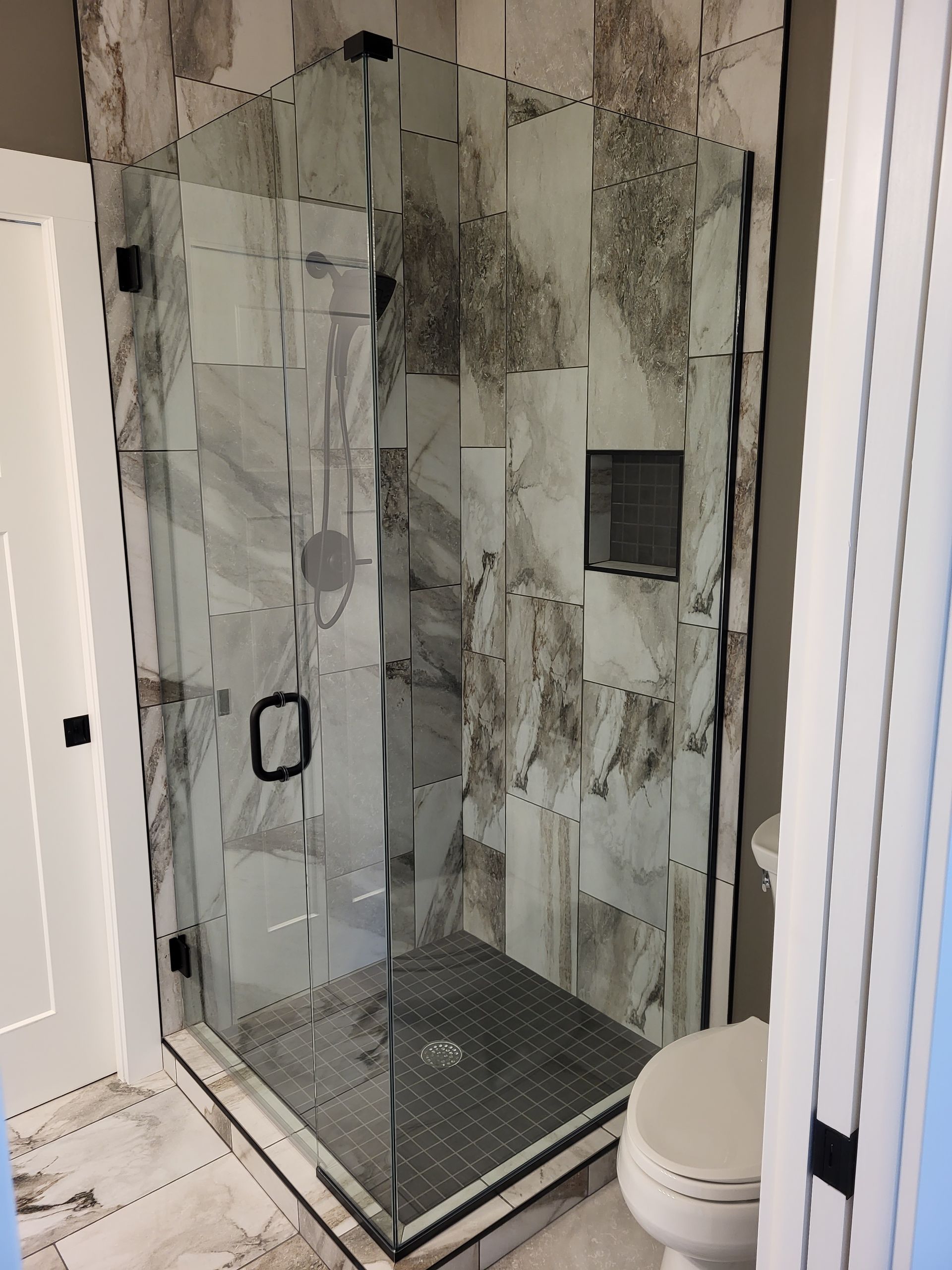 A bathroom with a walk in shower and a toilet