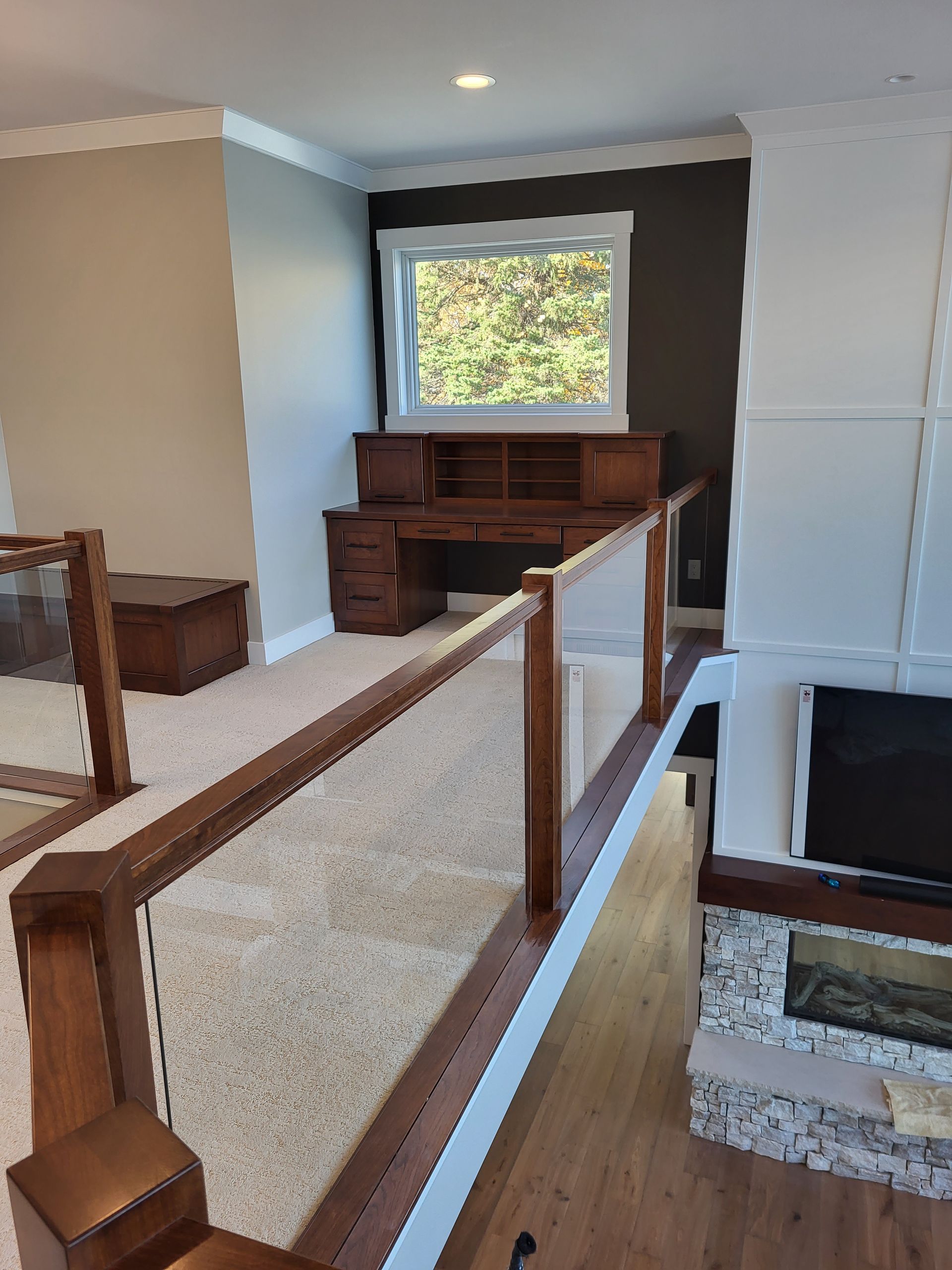 A living room with a desk and a fireplace