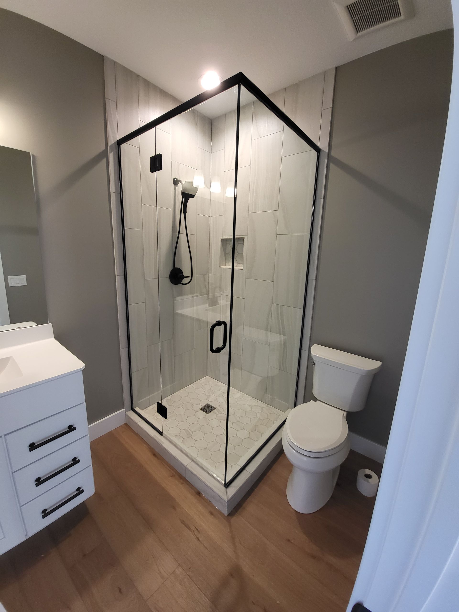 A bathroom with a toilet a sink and a shower