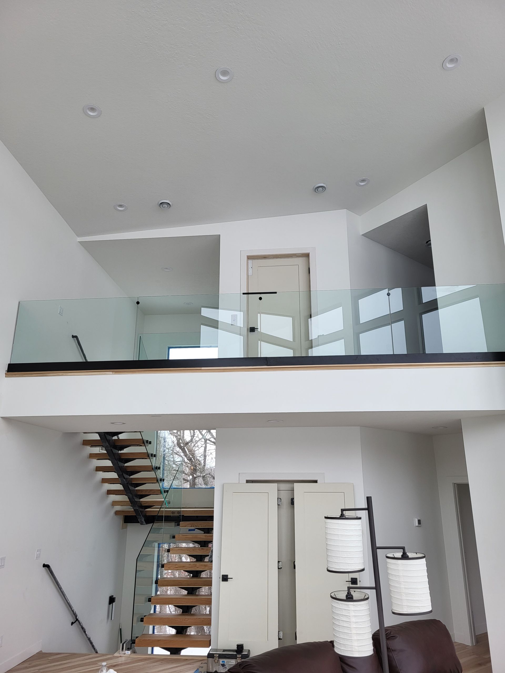 A living room with a staircase and a balcony