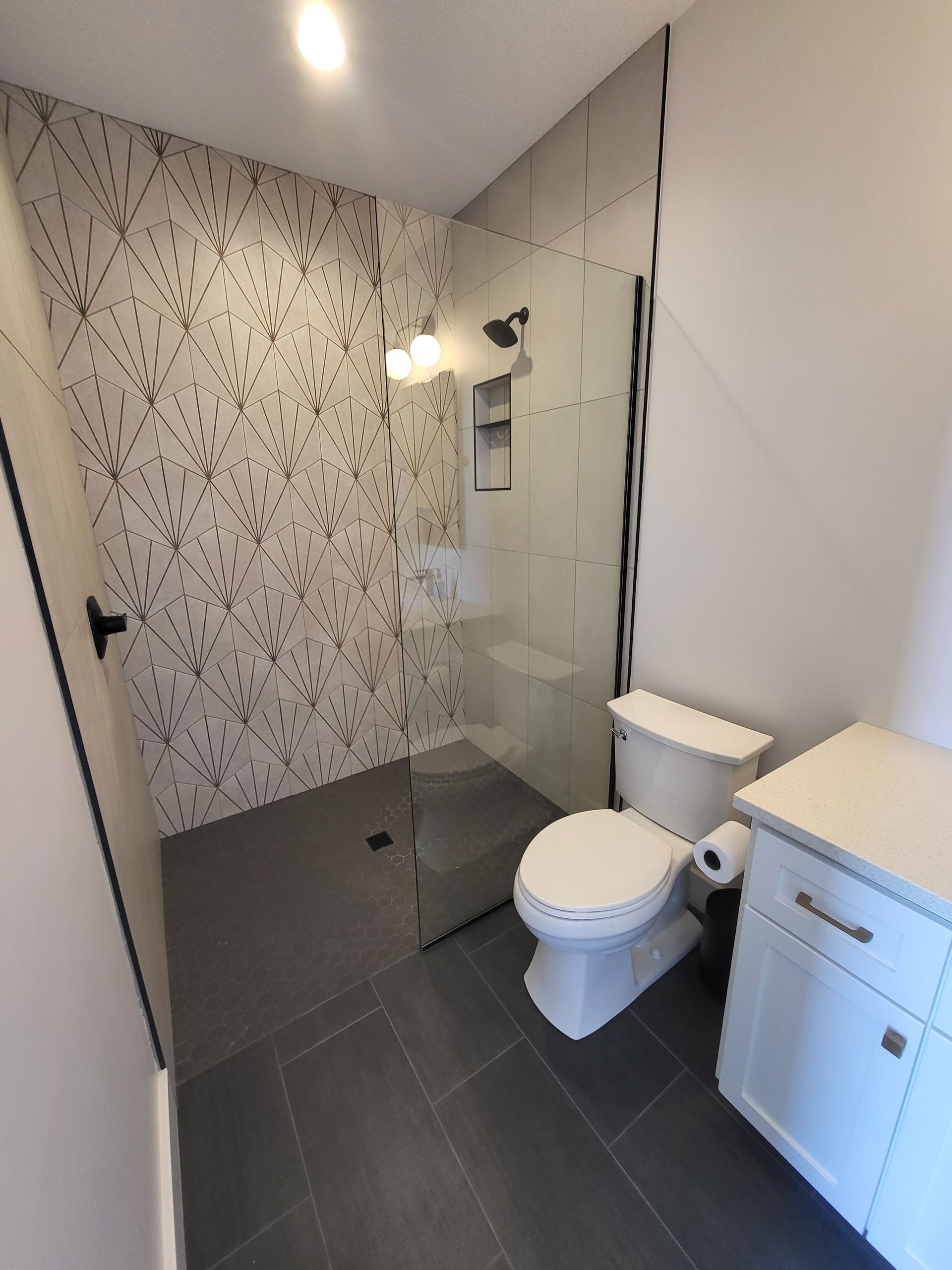 A bathroom with a toilet , sink and walk in shower