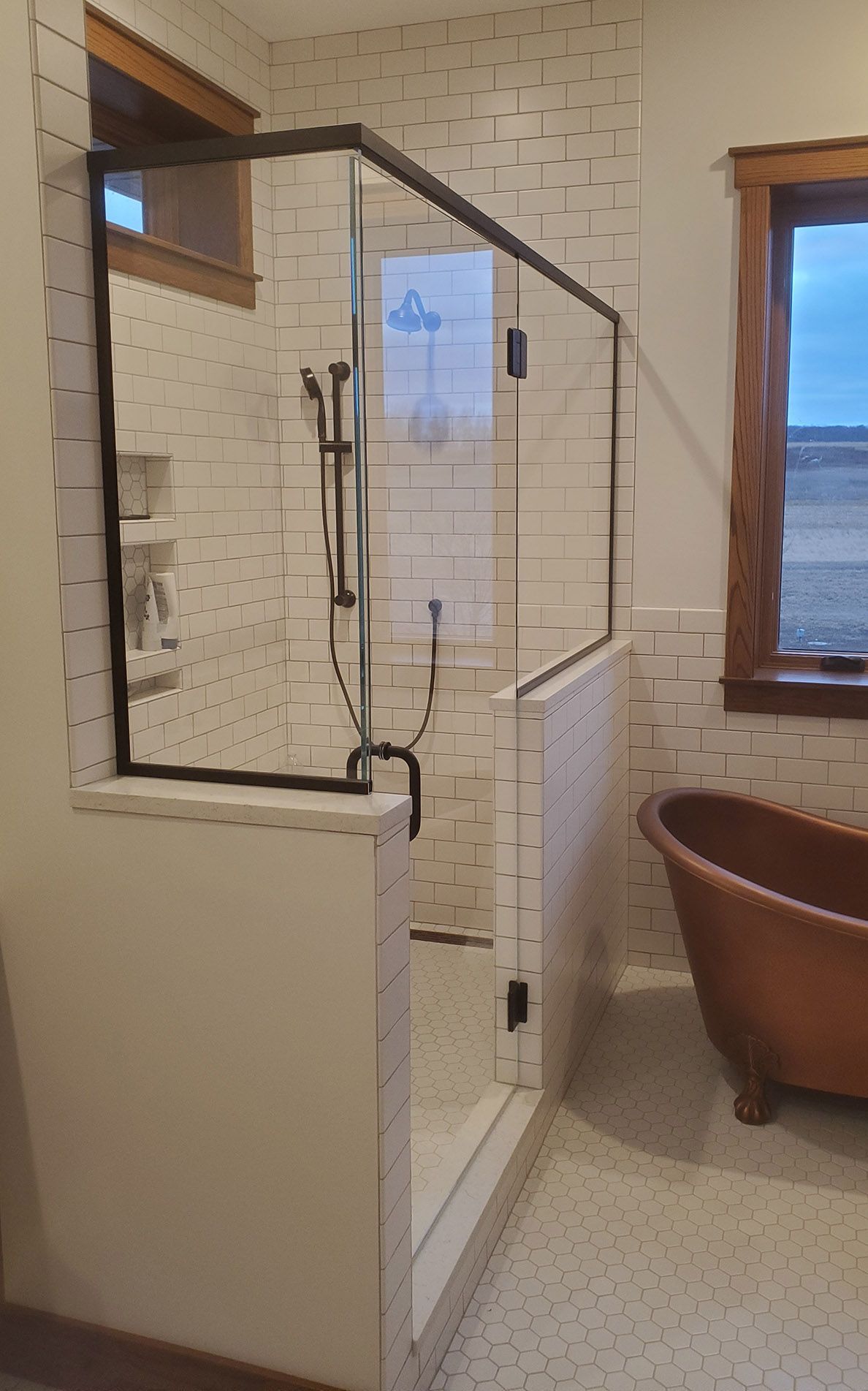 A bathroom with a tub and a shower with a glass door