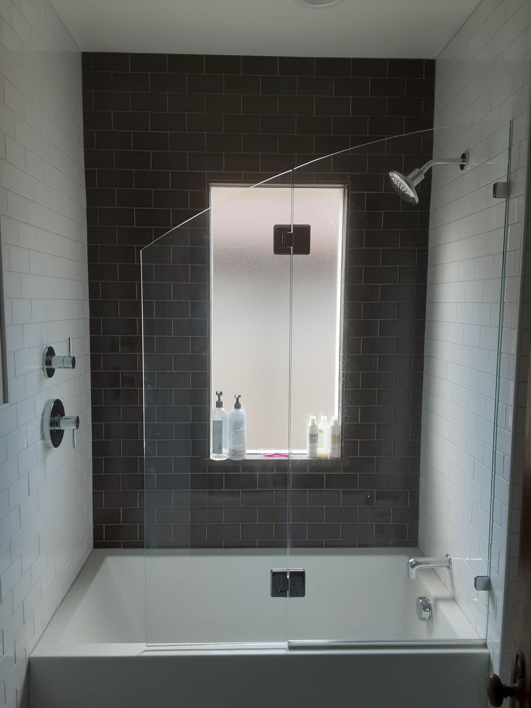 A bathroom with a bathtub and a window