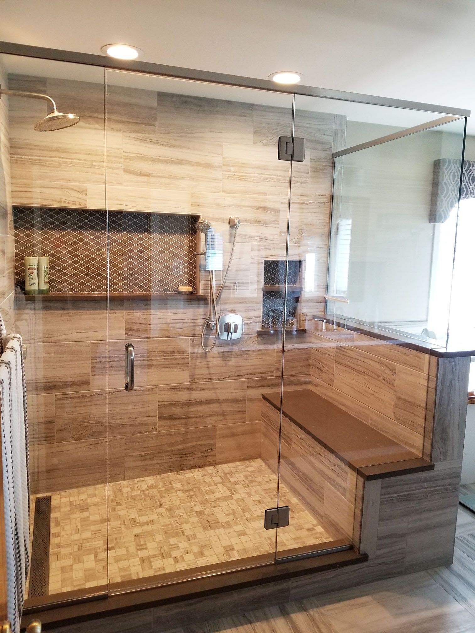 A bathroom with a walk in shower and a bench