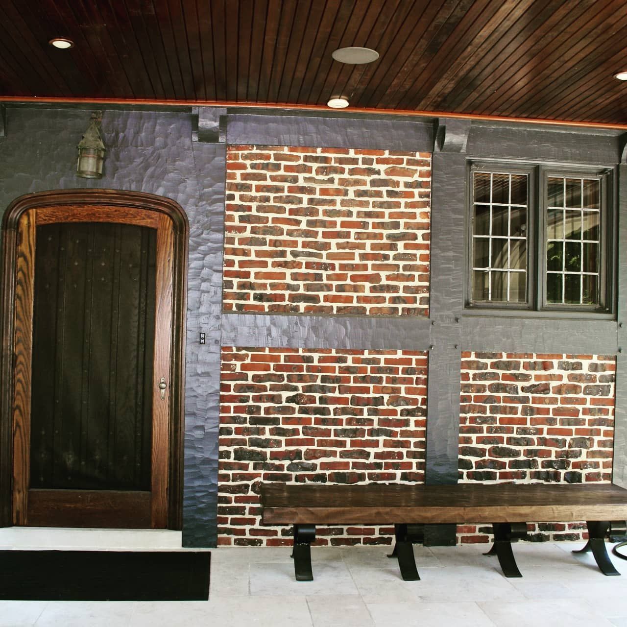 A brick wall with a wooden bench in front of it