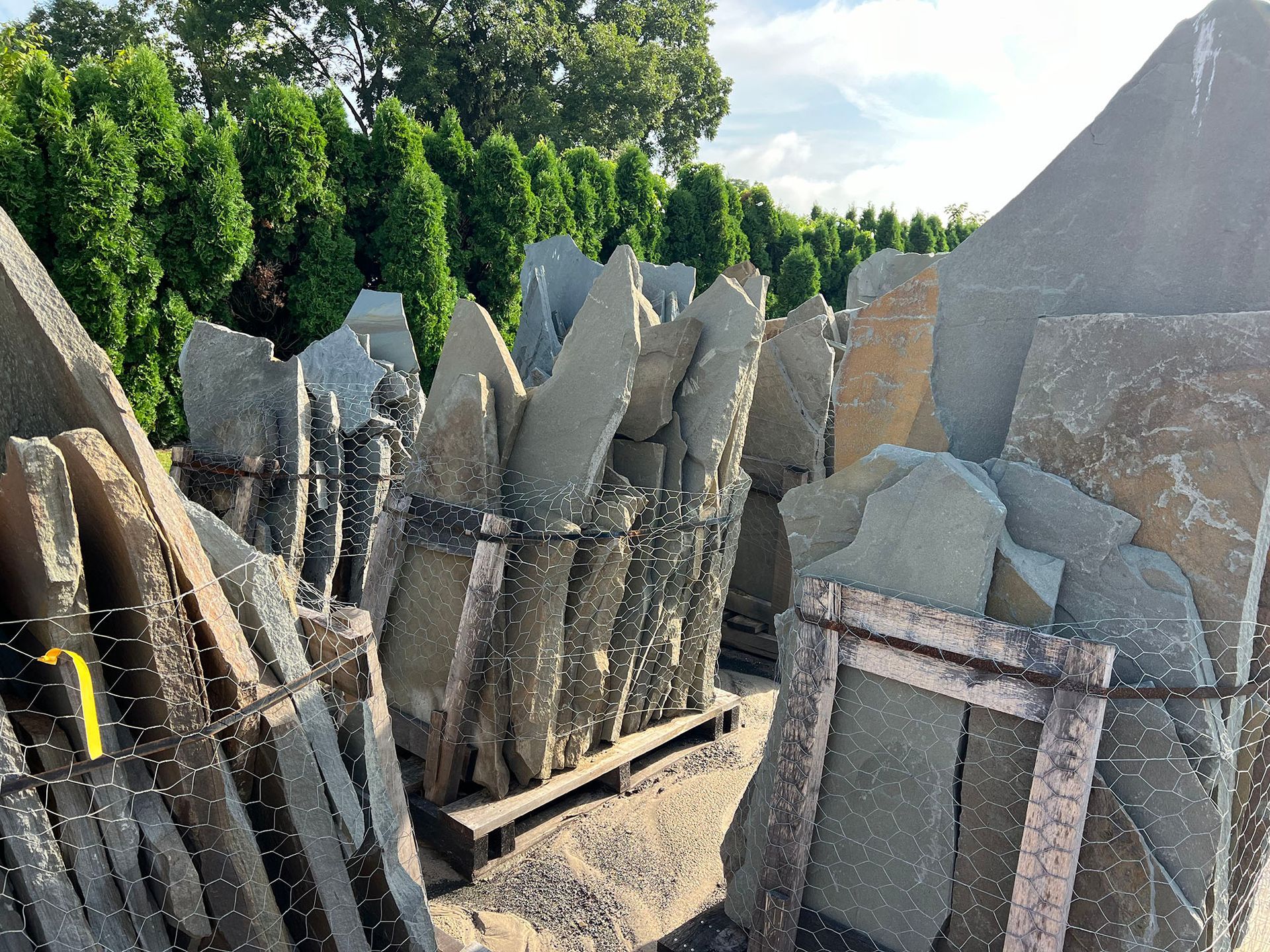 A bunch of rocks are stacked on top of each other in a yard.