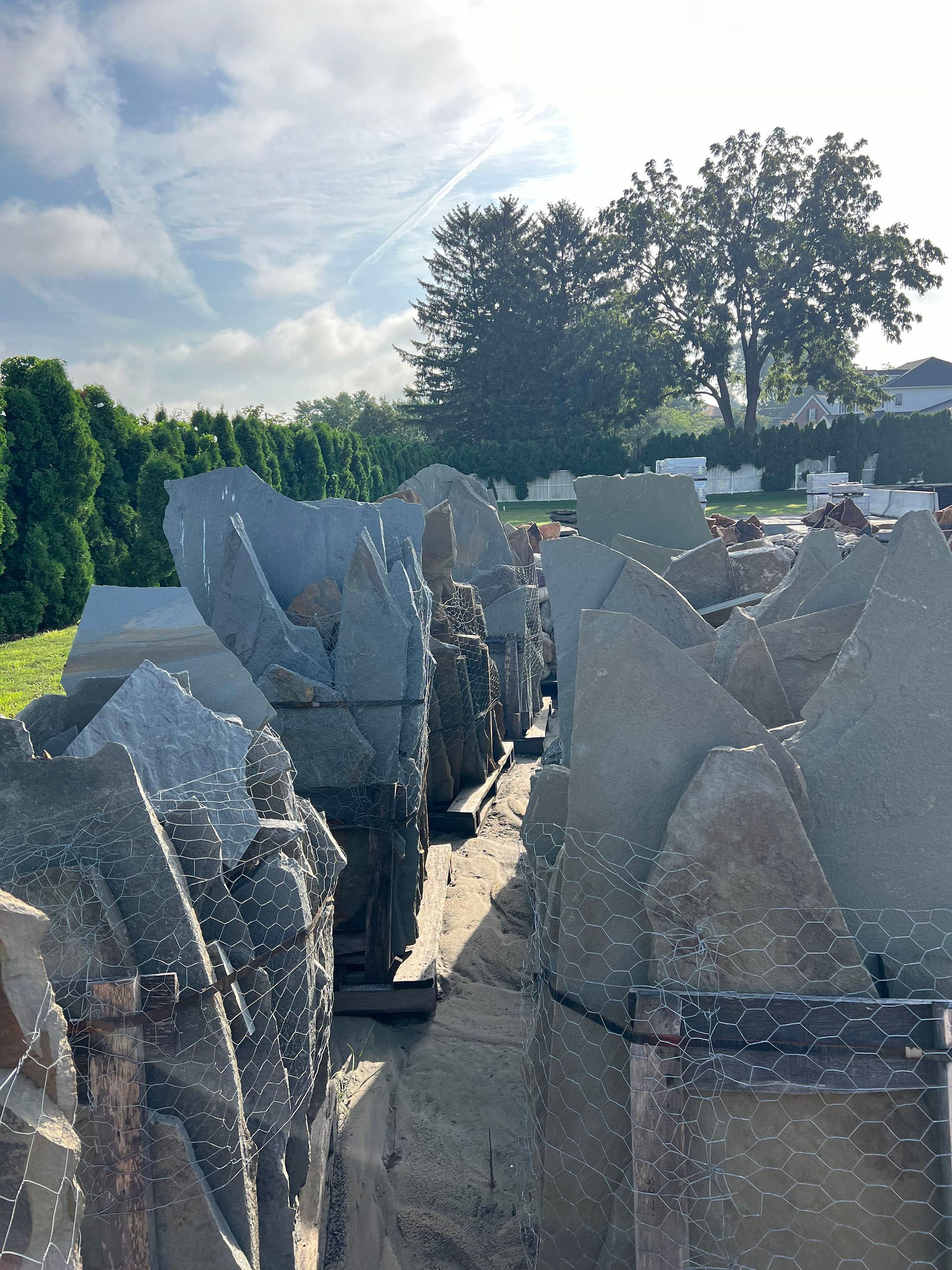 A pile of rocks in a field with trees in the background