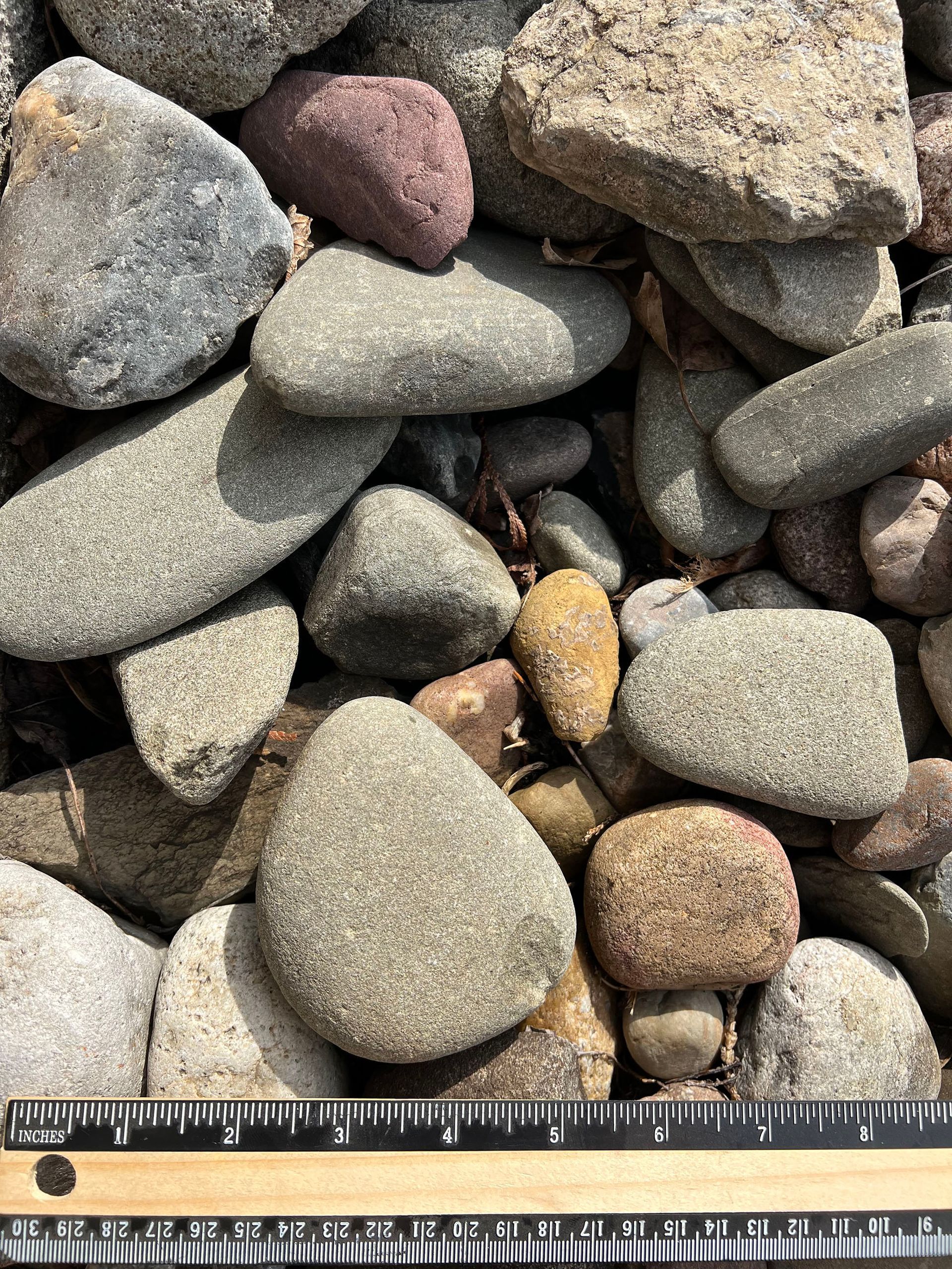 A pile of rocks is being measured with a ruler.