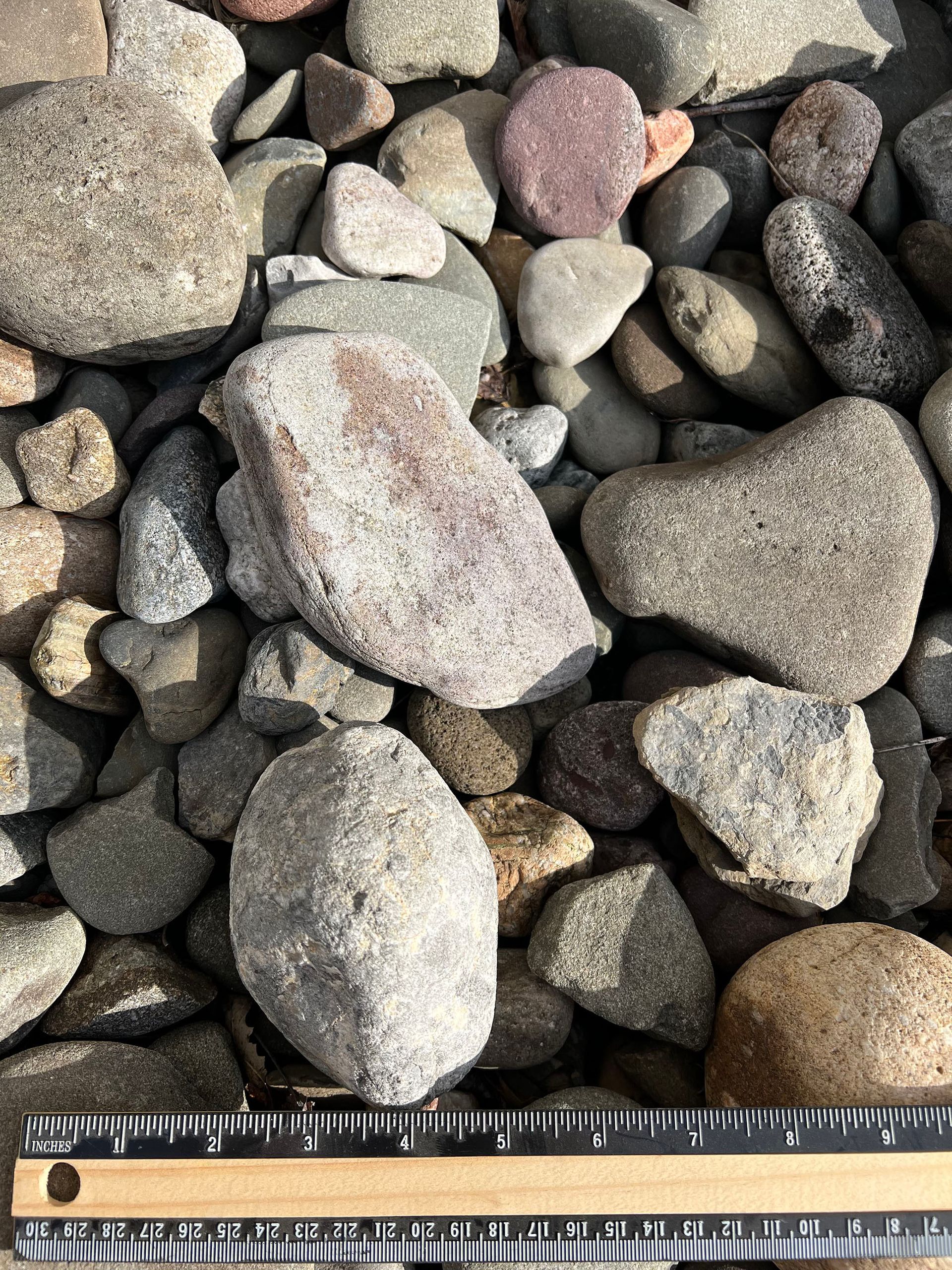 A pile of rocks is being measured with a ruler