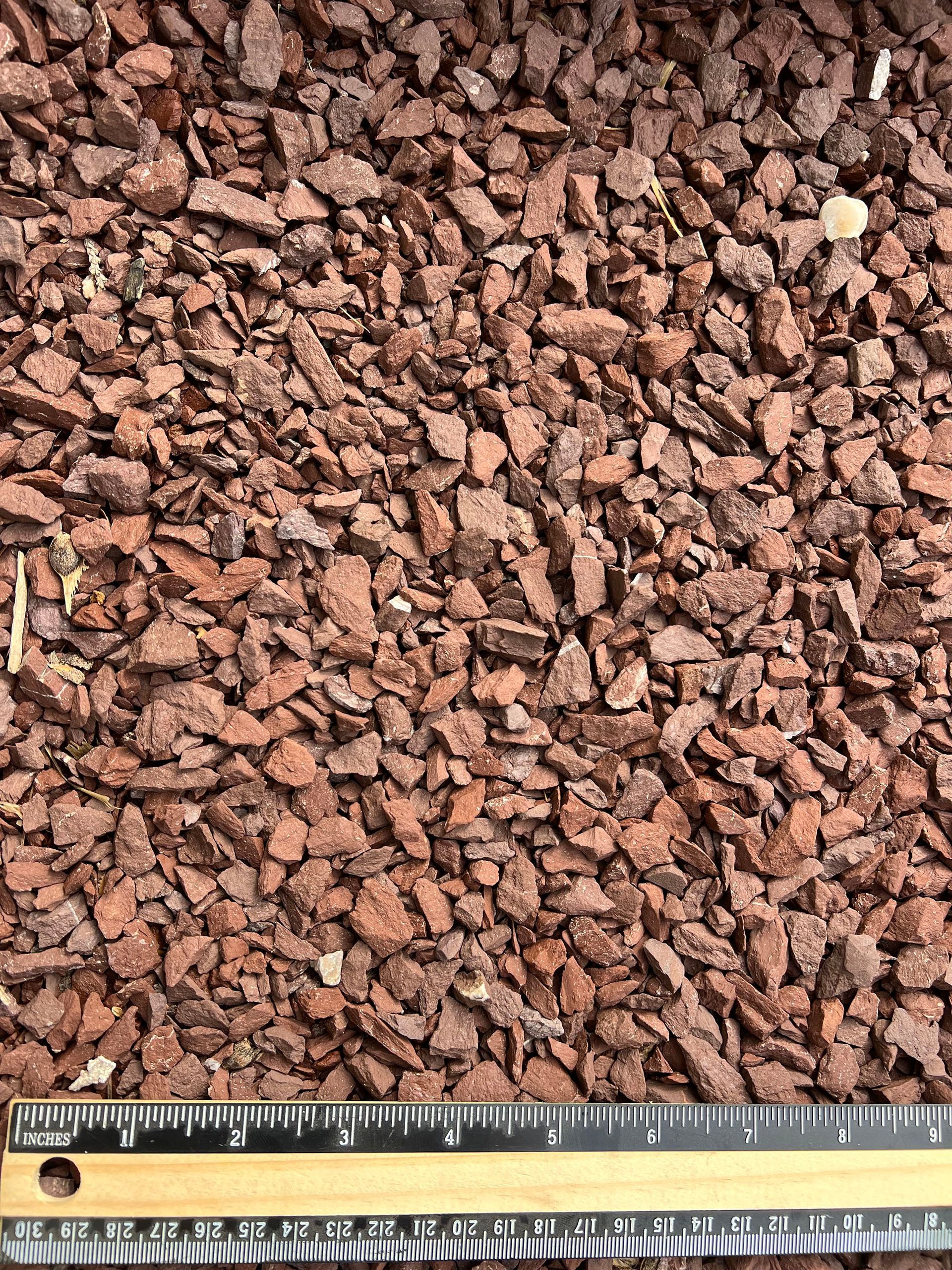 A ruler is laying on top of a pile of rocks.