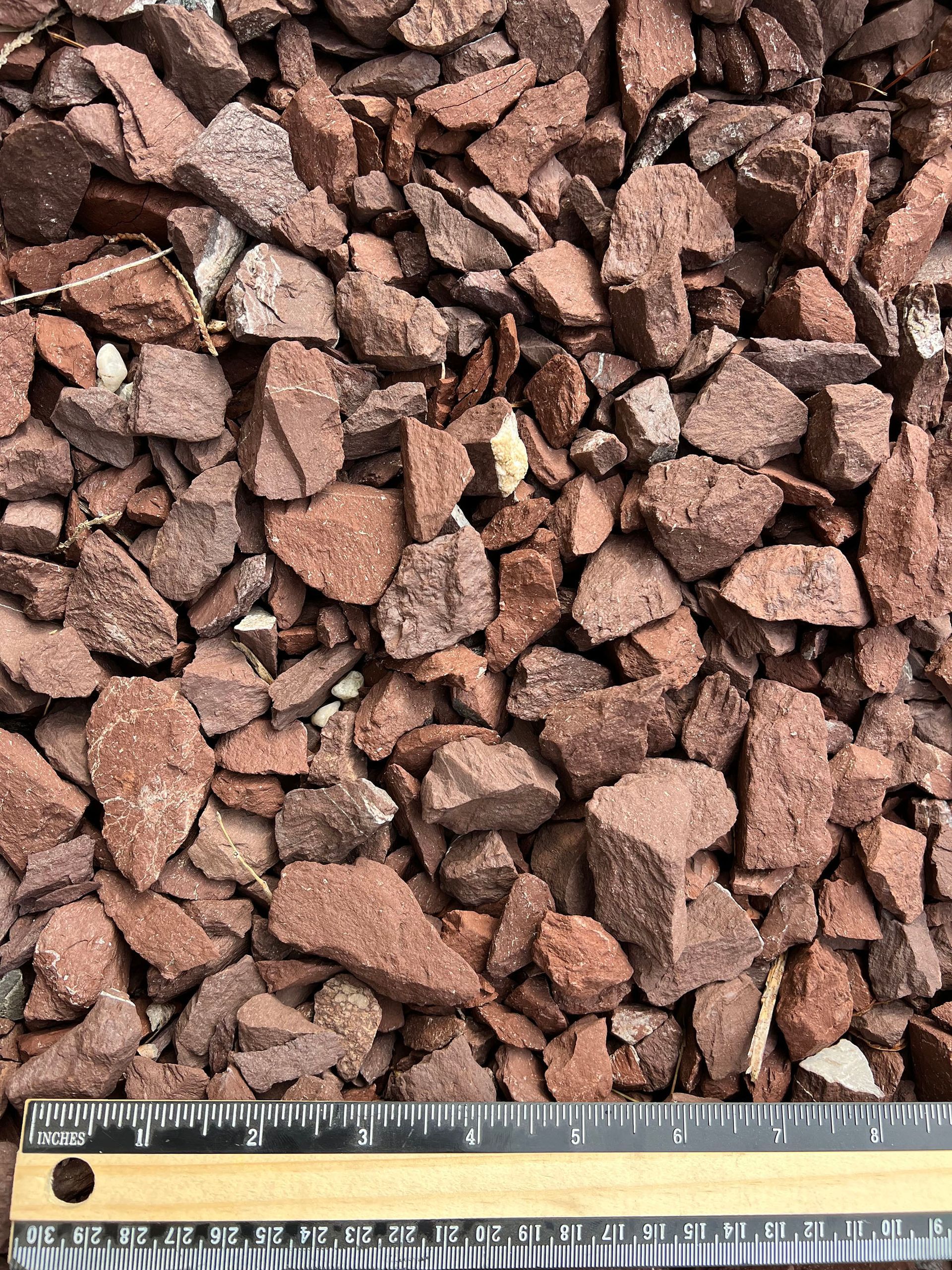 A pile of rocks is being measured with a ruler.