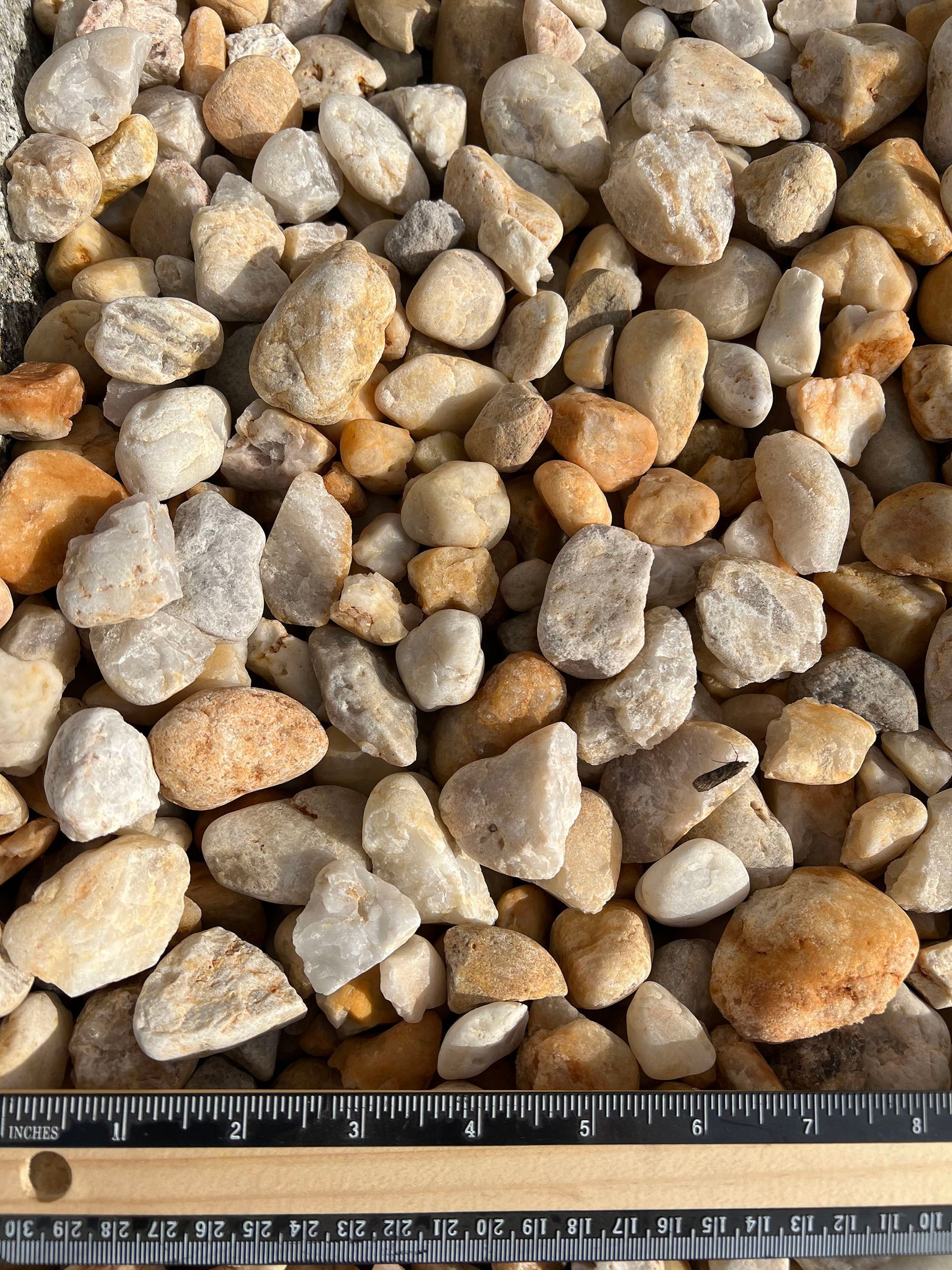 A pile of rocks is being measured by a ruler