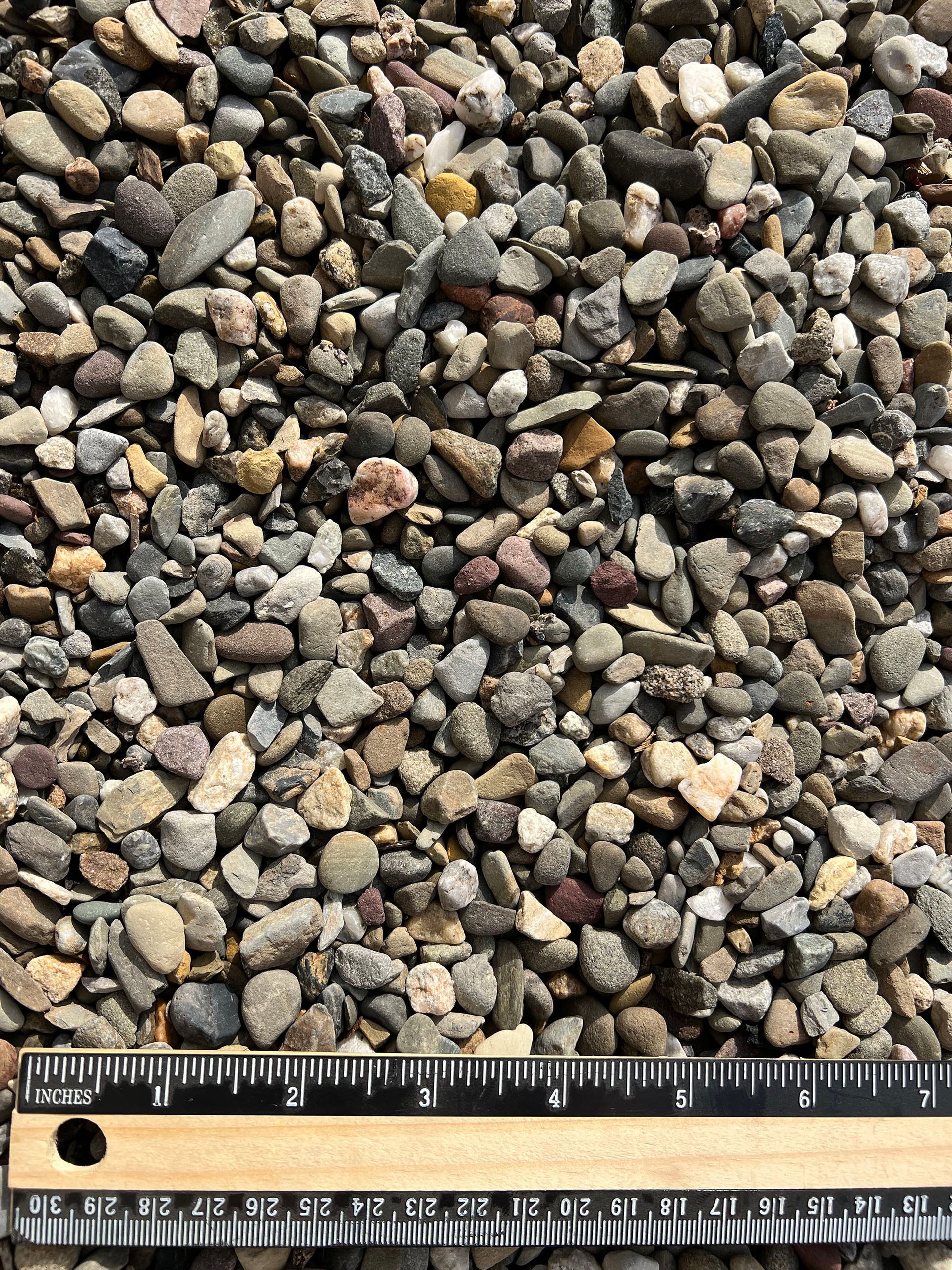 A ruler is sitting on top of a pile of rocks.