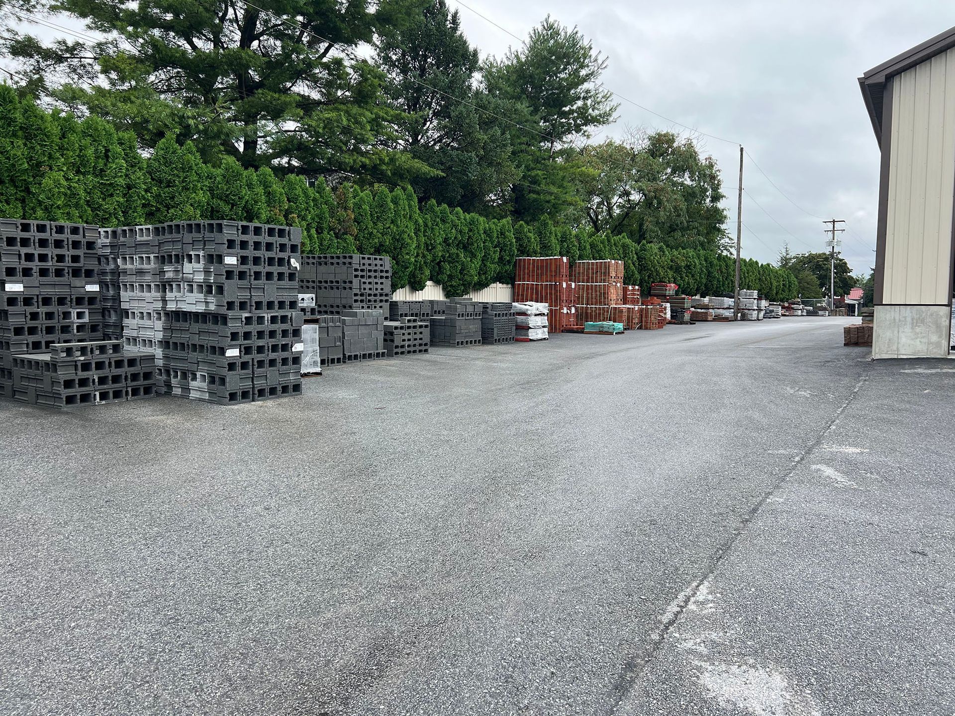 A lot of bricks are stacked on top of each other in a parking lot.