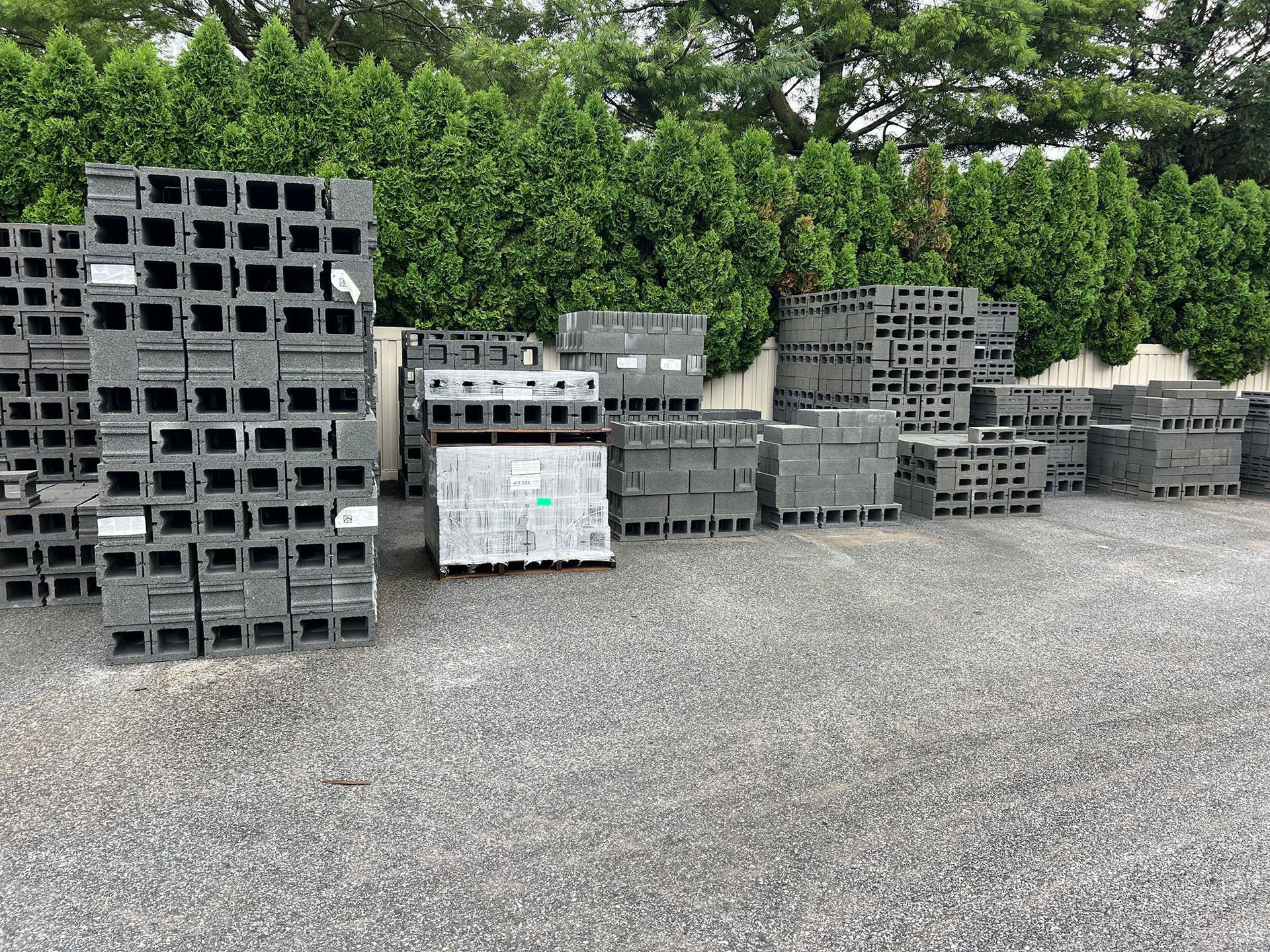 A lot of concrete blocks are stacked on top of each other in a parking lot.