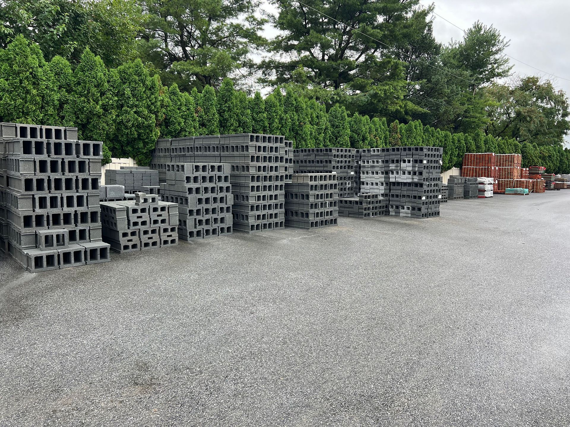 A lot of bricks are stacked on top of each other in a parking lot.