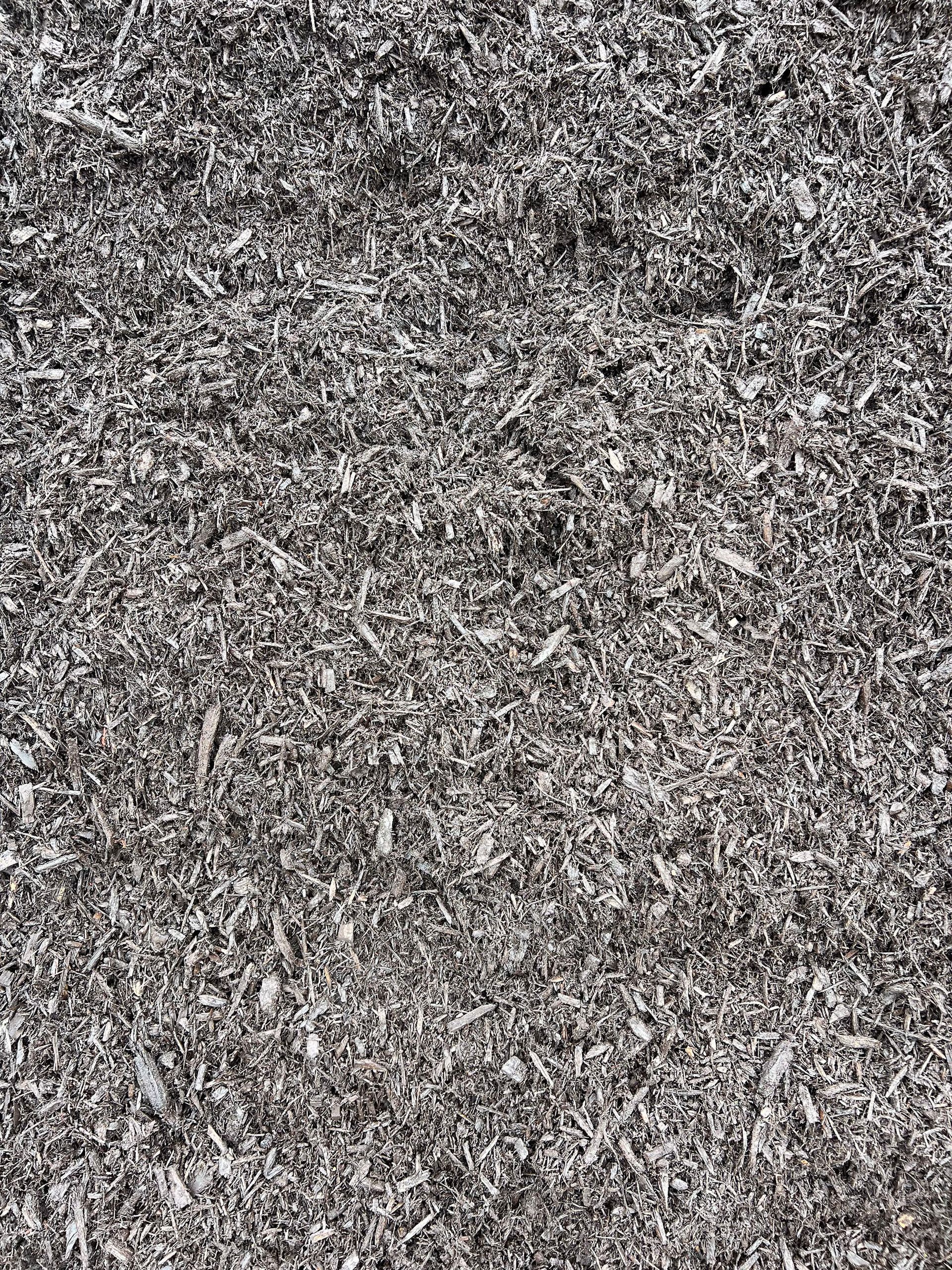 A pile of wood chips is sitting on the ground.