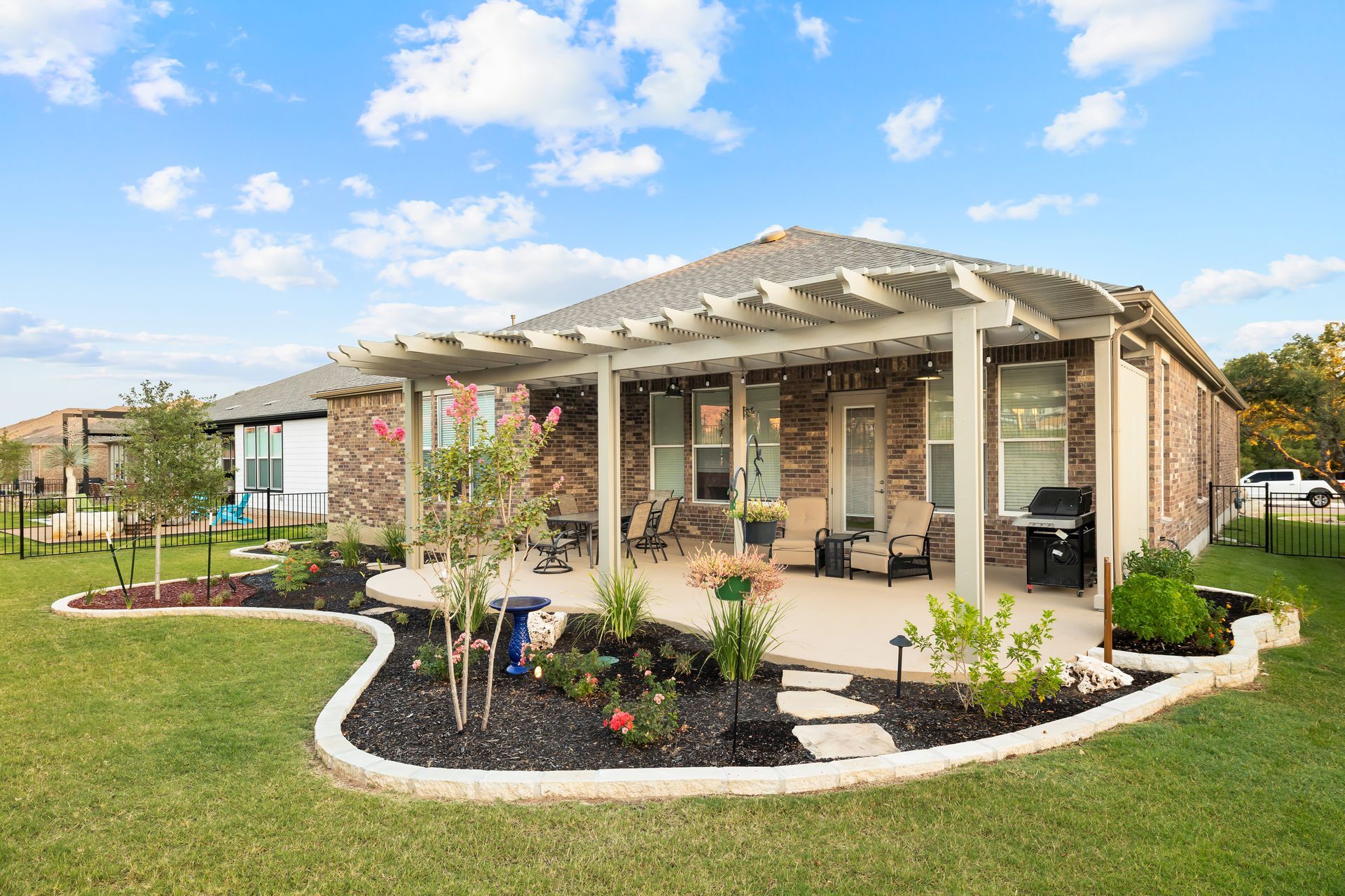 A house with a patio and a pergola in the backyard.