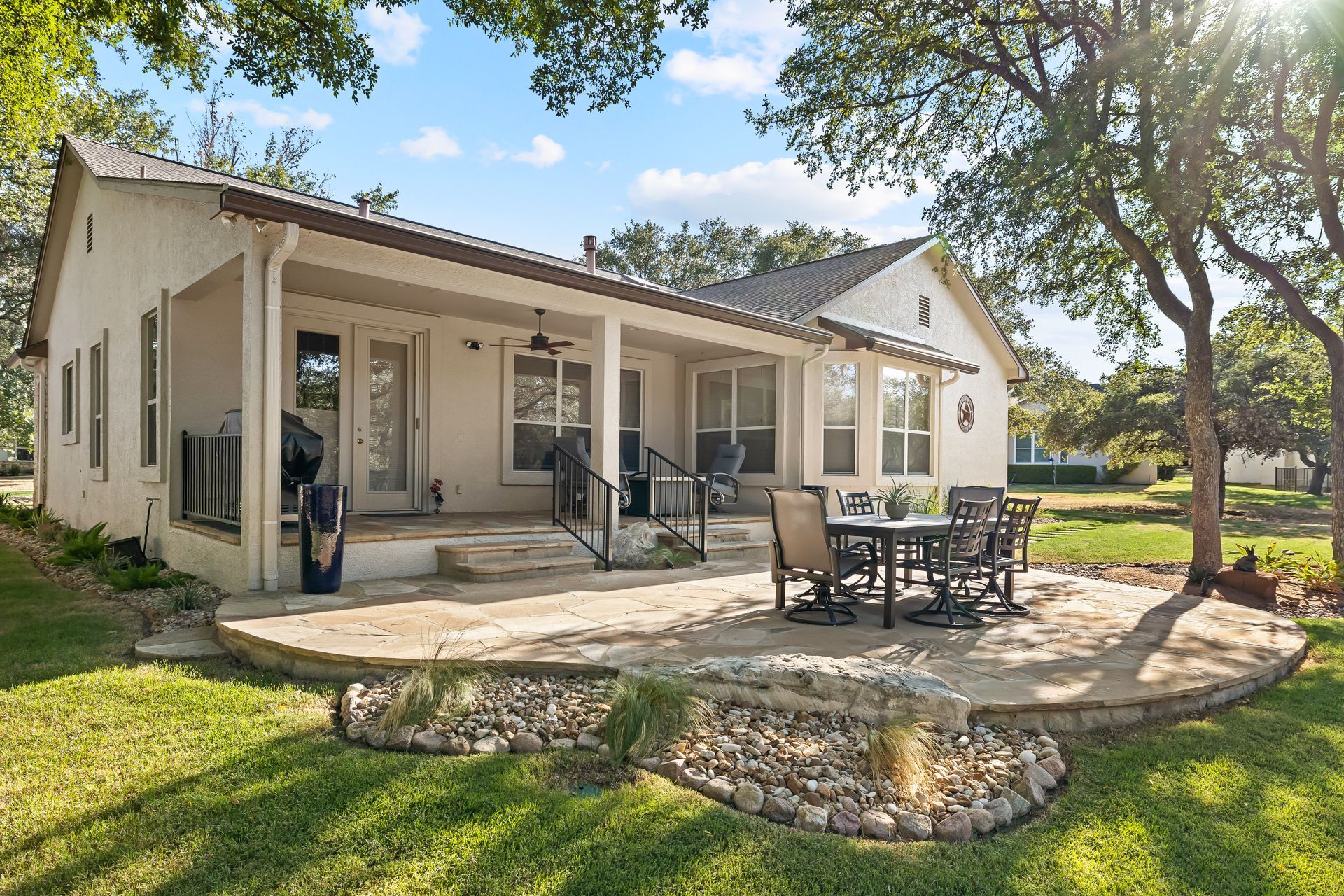 A white house with a patio and a table and chairs on it.