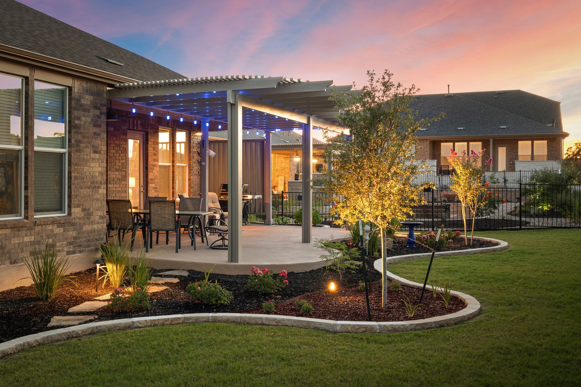 A house with a patio and a pergola in the backyard.
