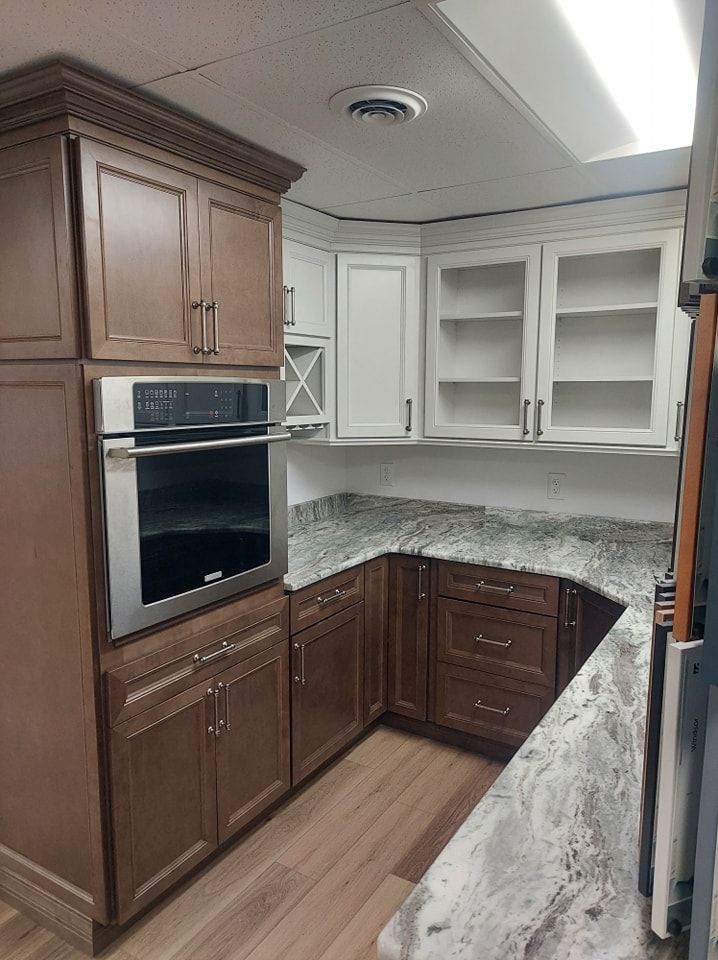 Kitchen with brown and white cabinets, granite countertops, and built-in oven.