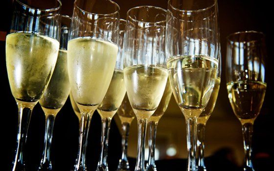 A row of champagne flutes filled with champagne on a table