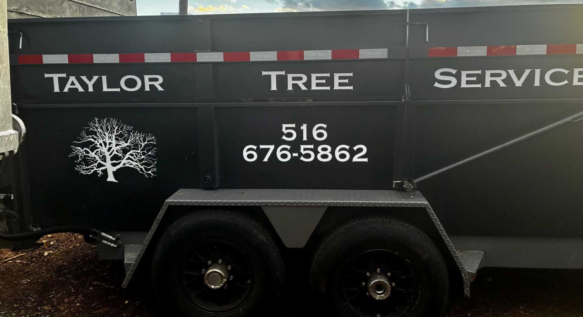 Black trailer with Taylor Tree Service tree graphic, and phone number